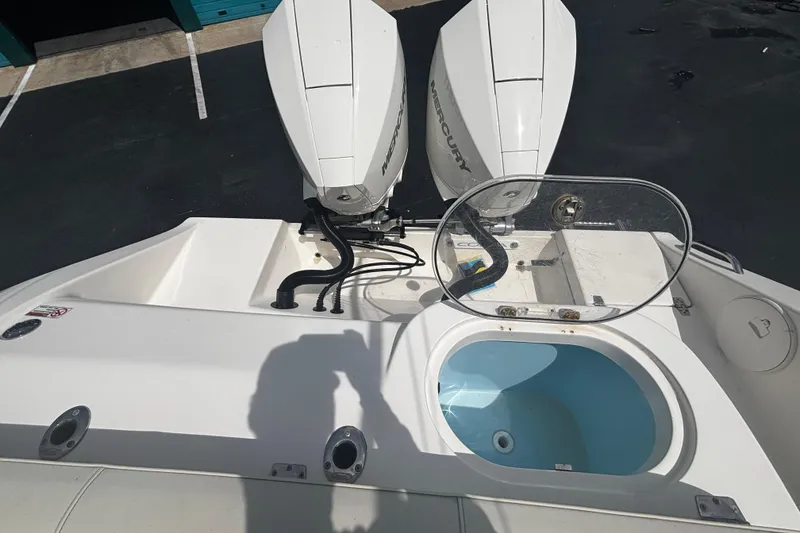 Slide: The Image of 2023 Cobia 262 Center Console boat with dual Mercury engines and open livewell. - 11