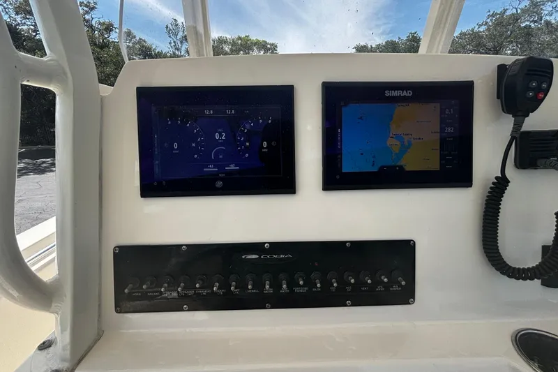 Slide: The Image of 2023 Cobia 262 Center Console dashboard with dual displays and control panel. - 12