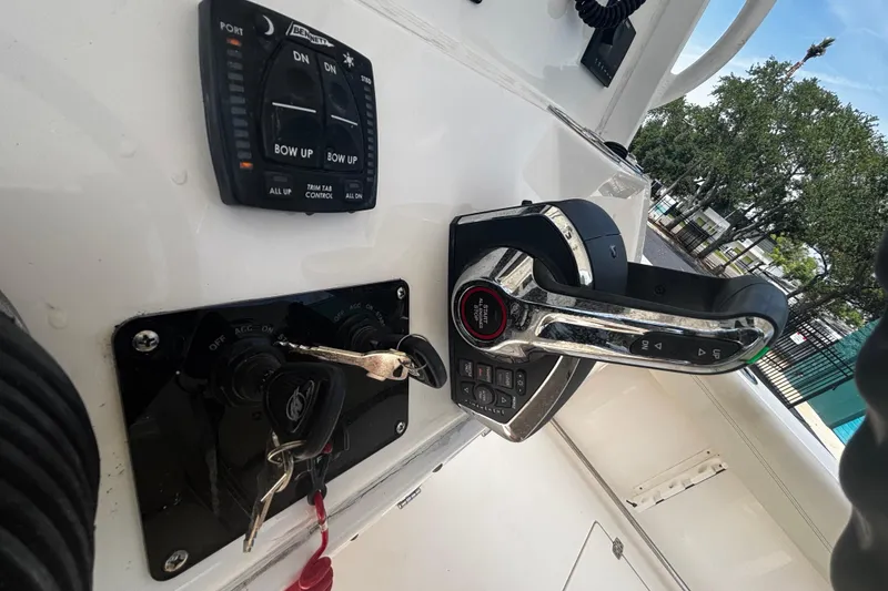 Slide: The Image of 2023 Cobia 262 Center Console boat controls with trim tab and throttle lever. - 13