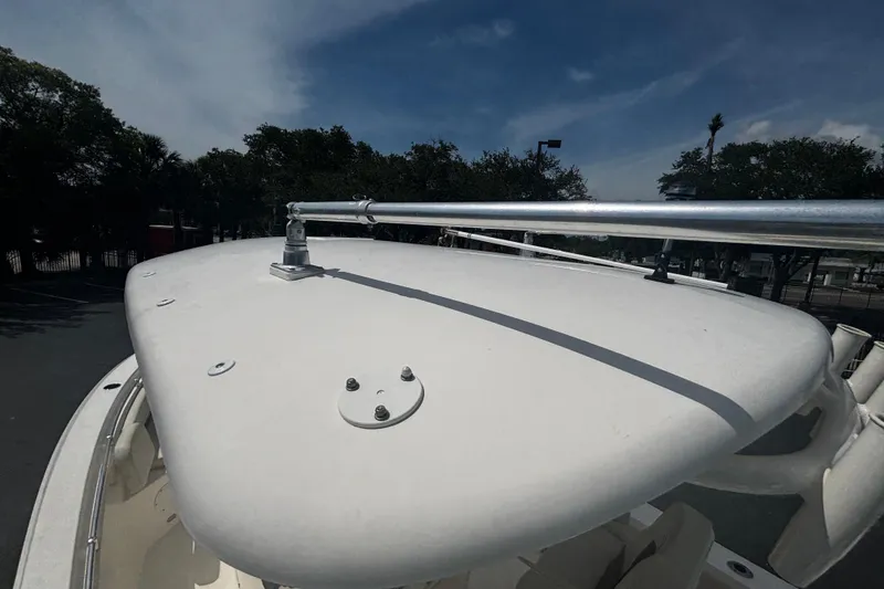 Slide: The Image of 2023 Cobia 262 Center Console boat with T-top under a clear blue sky. - 14