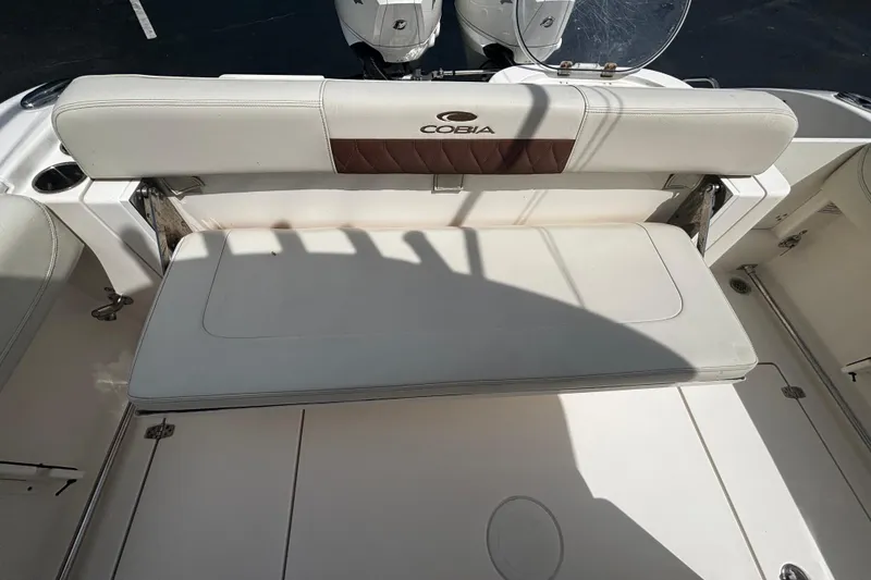 Slide: The Image of 2023 Cobia 262 Center Console boat with white cushioned seating and sleek design. - 15