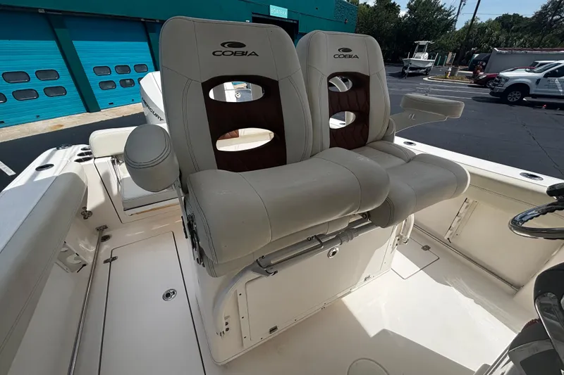 Slide: The Image of 2023 Cobia 262 Center Console boat with dual cushioned seats and armrests. - 16