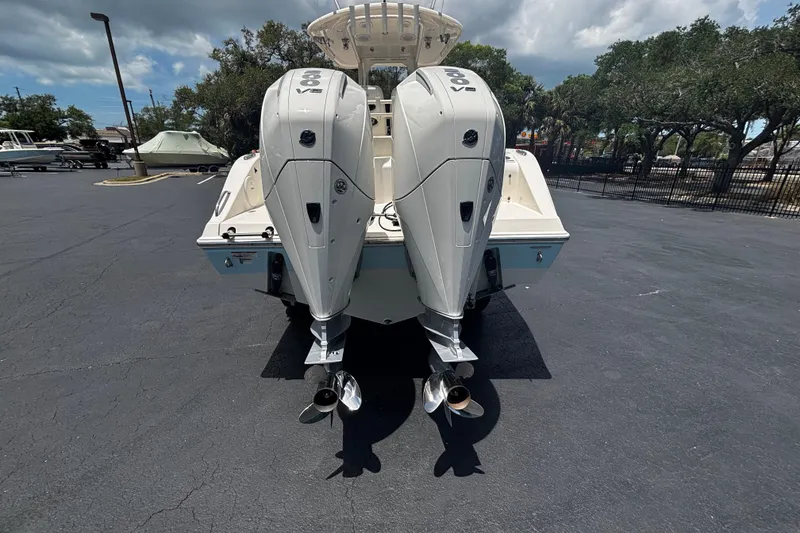 Slide: The Image of 2023 Cobia 262 Center Console boat with dual outboard engines in a parking lot. - 3