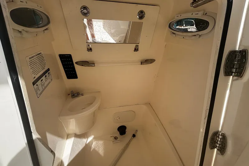 Slide: The Image of 2023 Cobia 262 Center Console boat interior with sink and mirror. - 9