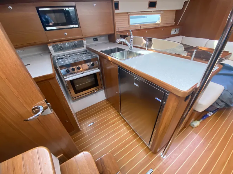 Slide: The Image of Modern Catalina 426 yacht kitchen with wood finish, stainless steel appliances, and sleek countertops. - 47