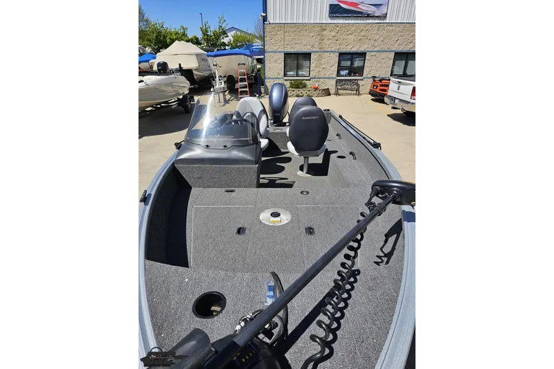 Slide: The Image of 2014 Alumacraft Classic 165 boat interior with seating and equipment, parked outdoors. - 12