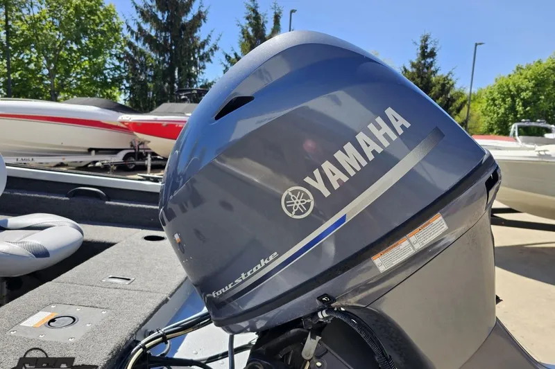 Slide: The Image of 2014 Alumacraft Classic 165 boat with Yamaha four-stroke outboard motor, parked outdoors. - 24