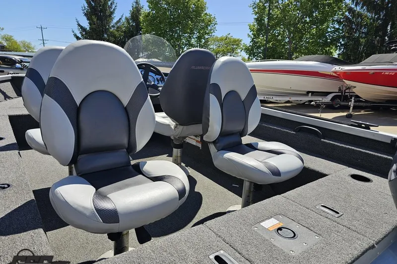 Slide: The Image of 2014 Alumacraft Classic 165 boat interior with two gray seats, steering wheel, and dashboard. - 26