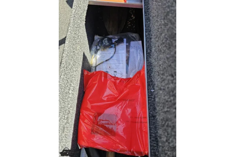 Slide: The Image of Red bag and documents inside 2014 Alumacraft Classic 165 boat compartment. - 39