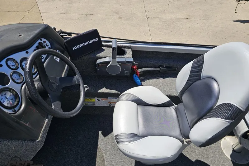 Slide: The Image of 2014 Alumacraft Classic 165 boat interior with steering wheel, gauges, and Humminbird device. - 42
