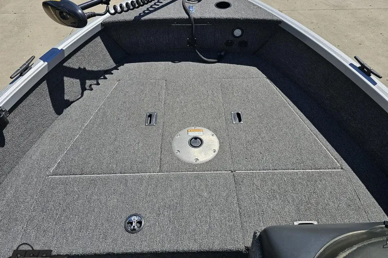 Slide: The Image of 2014 Alumacraft Classic 165 boat interior with carpeted deck and storage compartments. - 48