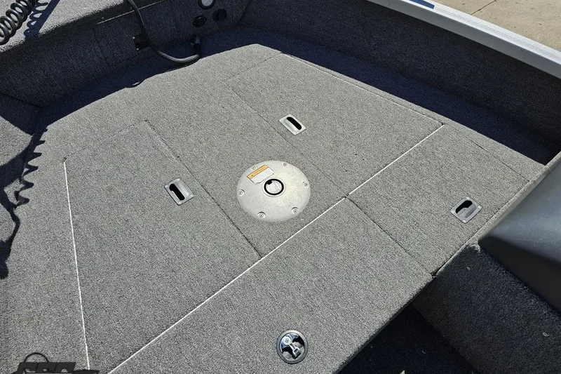 Slide: The Image of 2014 Alumacraft Classic 165 boat interior with gray carpeted deck and storage compartments. - 49