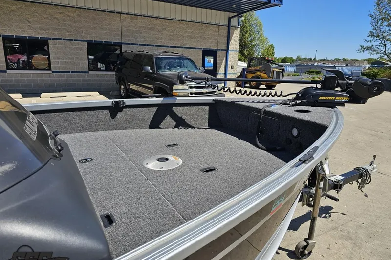 Slide: The Image of 2014 Alumacraft Classic 165 boat with Minn Kota trolling motor in a parking lot. - 5