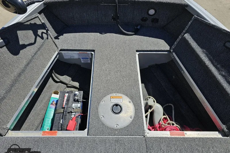 Slide: The Image of 2014 Alumacraft Classic 165 boat interior storage compartments with battery and rope. - 52