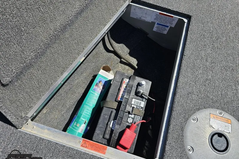 Slide: The Image of 2014 Alumacraft Classic 165 boat battery compartment with battery and storage items. - 54