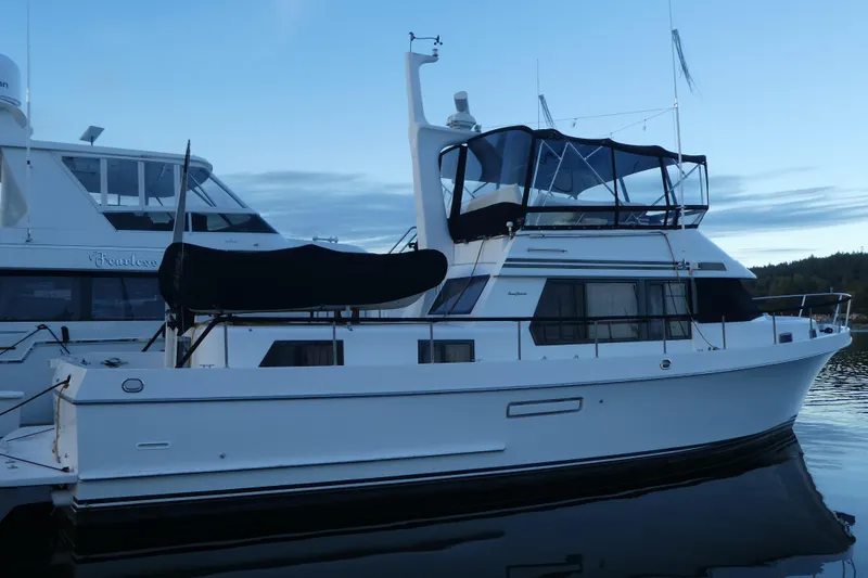 Slide: The Image of 1992 Ocean Alexander 456 Classicco yacht docked at sunset, featuring sleek design and spacious deck. - 2