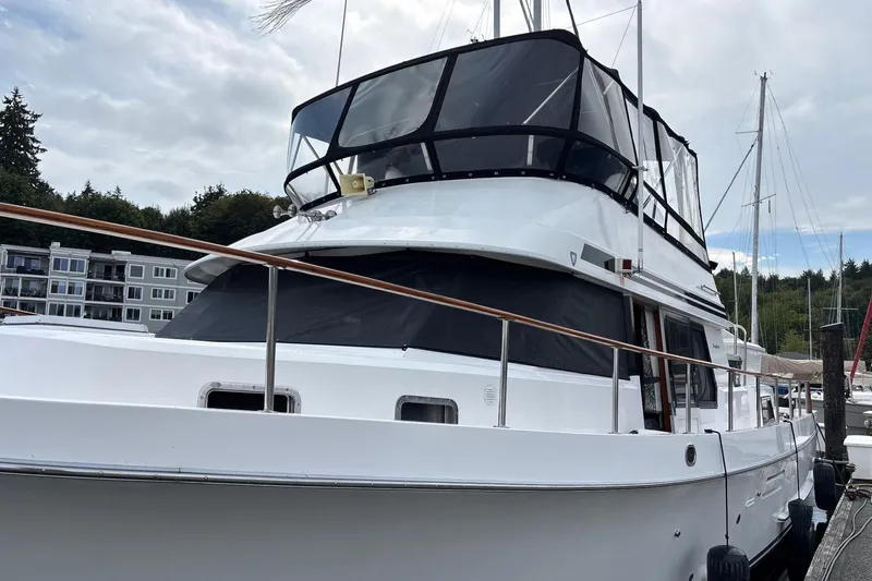 Slide: The Image of 1992 Ocean Alexander 456 Classicco yacht docked at marina, featuring sleek design and spacious deck. - 5