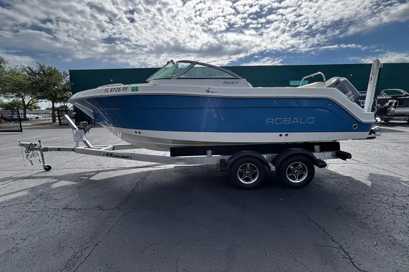 The Image of 2012 Robalo R227 Dual Console boat on trailer under cloudy sky. - 1