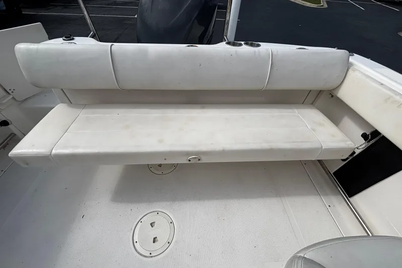 Slide: The Image of 2012 Robalo R227 Dual Console boat with white cushioned seating and cup holders. - 4