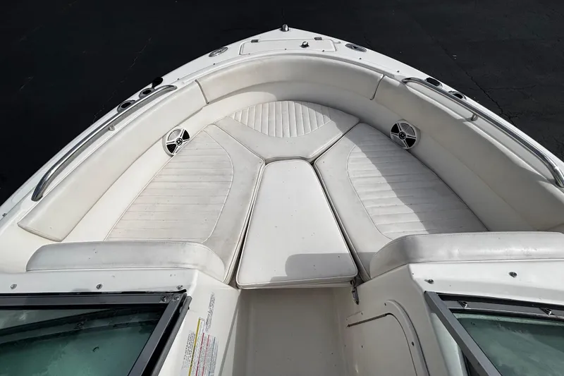 Slide: The Image of 2012 Robalo R227 Dual Console boat interior with white cushioned seating and speakers. - 6