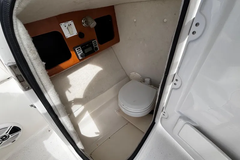 Slide: The Image of 2012 Robalo R227 Dual Console boat interior with compact marine toilet and control panel. - 7