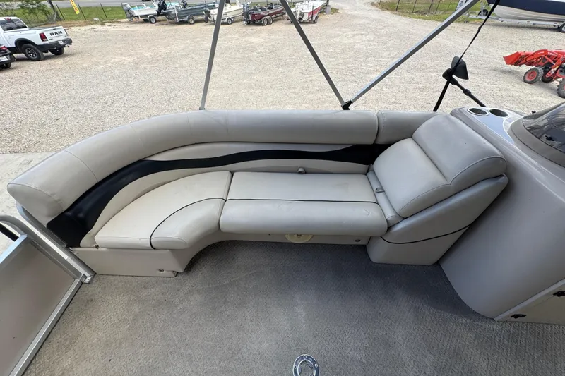 Slide: The Image of 2011 Veranda Tritoon boat interior with beige seating and cup holders. - 14