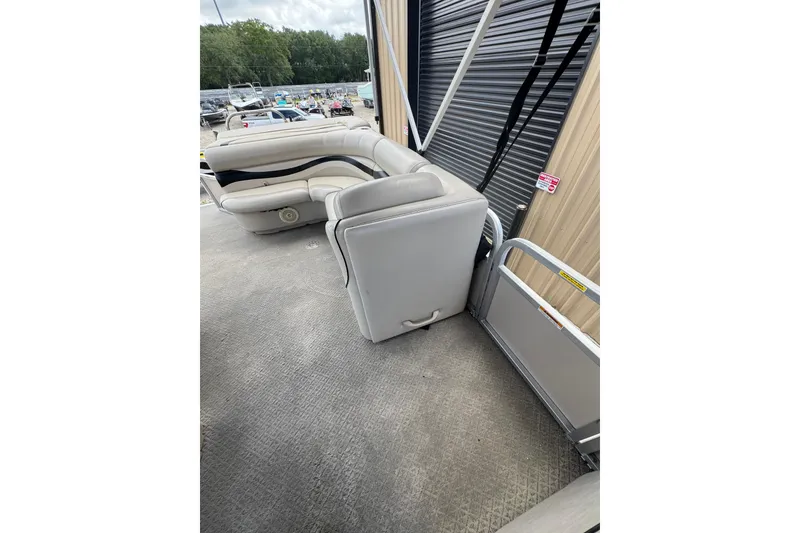 Slide: The Image of 2011 Veranda Tritoon boat interior with gray seating and textured flooring. - 16