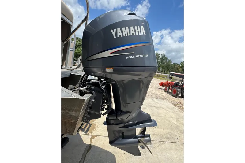 Slide: The Image of Yamaha four-stroke outboard motor on a 2011 Veranda Tritoon boat, outdoors. - 20