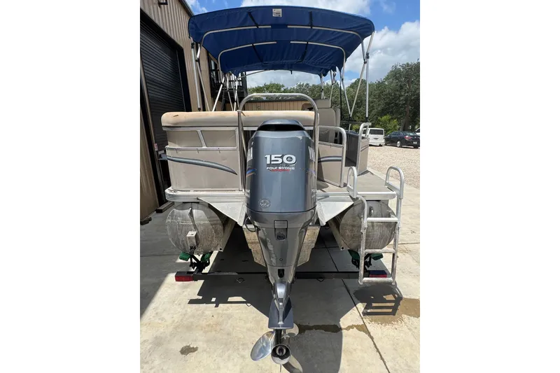 Slide: The Image of 2011 Veranda Tritoon boat with Yamaha 150 horsepower engine, parked outdoors. - 22