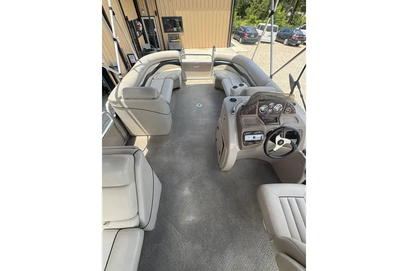 Slide: The Image of 2011 Veranda Tritoon boat interior with beige seating and steering console. - 7