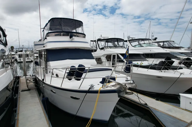 The Image of 1988 Sea Ranger 51 Motor Yacht docked at marina under cloudy sky. - 0