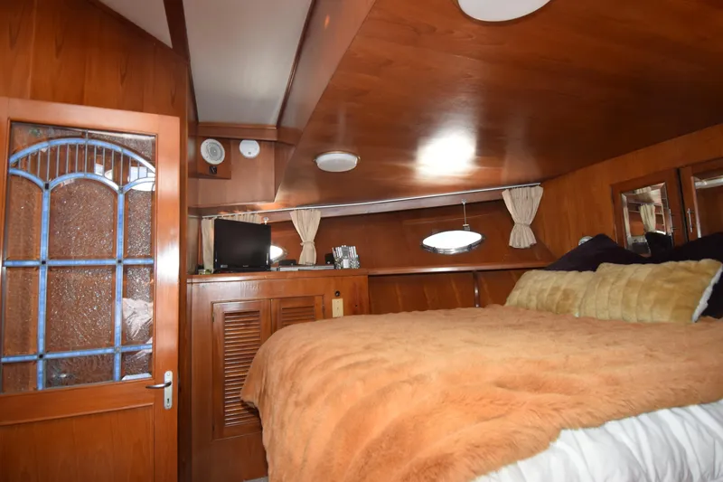 Slide: The Image of Cozy bedroom interior of 1988 Sea Ranger 51 Motor Yacht with wood paneling and plush bedding. - 14