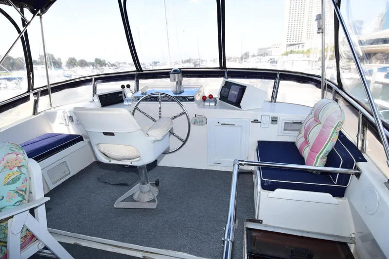 Slide: The Image of 1988 Sea Ranger 51 Motor Yacht helm with steering wheel, seating, and navigation equipment. - 18