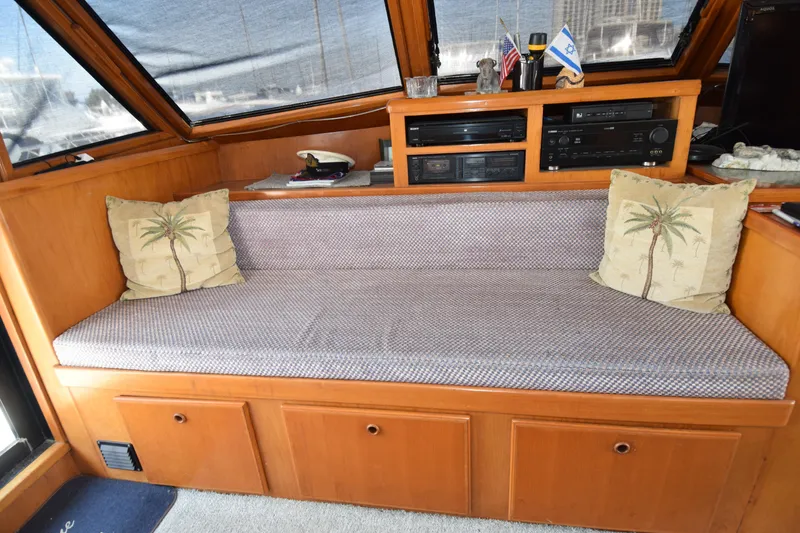 Slide: The Image of Interior of 1988 Sea Ranger 51 Motor Yacht with cushioned seating and decorative pillows. - 2