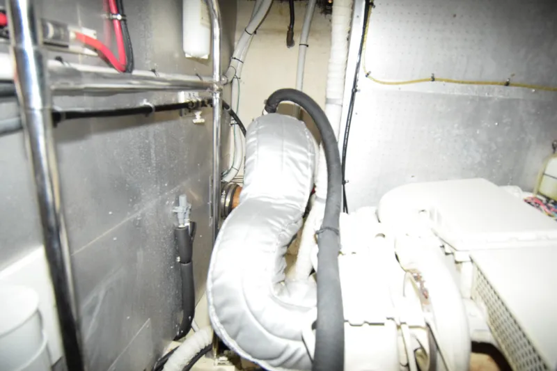 Slide: The Image of Engine room of 1988 Sea Ranger 51 Motor Yacht with visible piping and insulation. - 21