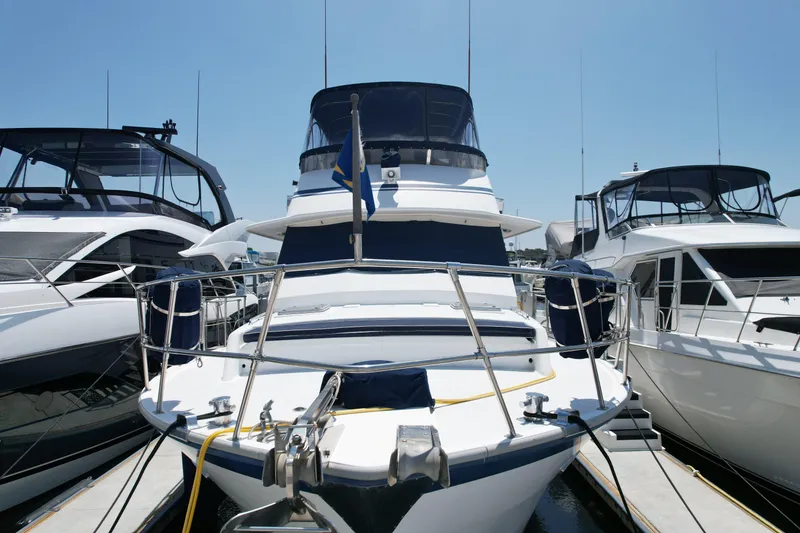 Slide: The Image of 1988 Sea Ranger 51 Motor Yacht docked between two boats under clear blue sky. - 25