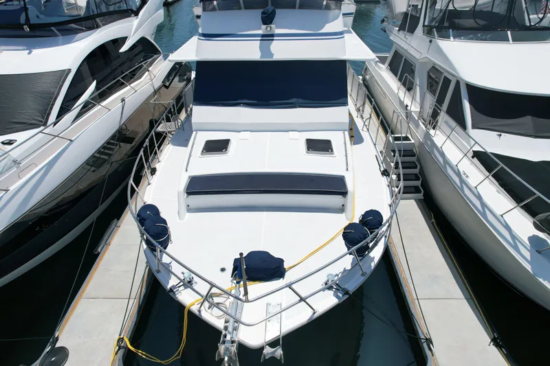 Slide: The Image of 1988 Sea Ranger 51 Motor Yacht docked between two boats at a marina. - 26