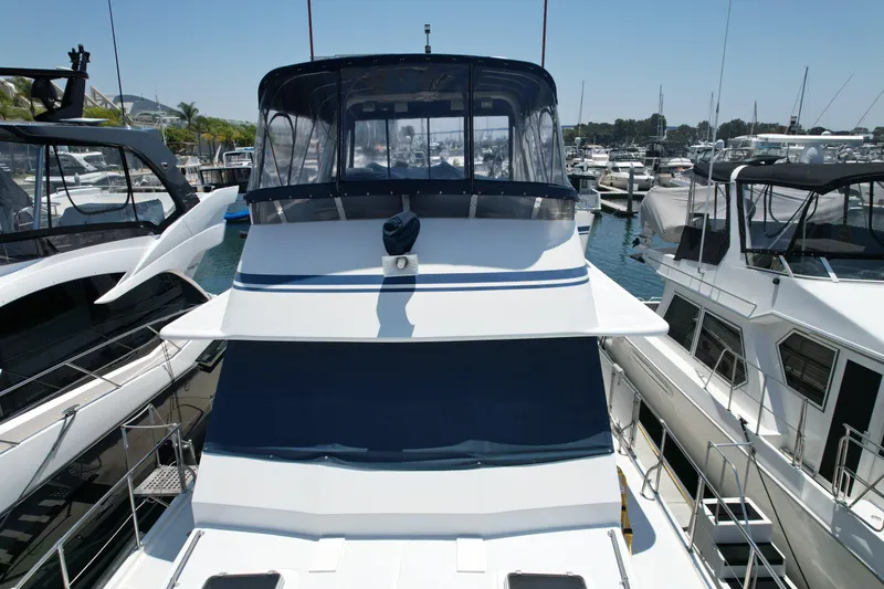Slide: The Image of 1988 Sea Ranger 51 Motor Yacht docked at a marina, surrounded by other boats. - 27