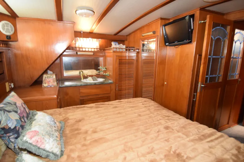Slide: The Image of Luxurious 1988 Sea Ranger 51 Motor Yacht cabin with wood paneling and cozy bedding. - 5