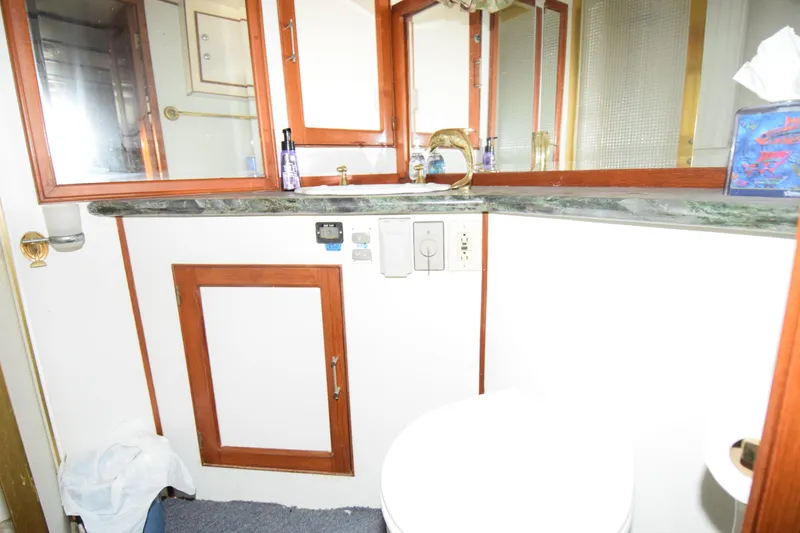 Slide: The Image of Bathroom interior of 1988 Sea Ranger 51 Motor Yacht with wooden cabinetry and marble countertop. - 7