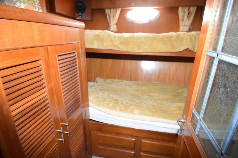 Slide: The Image of Interior of 1988 Sea Ranger 51 Motor Yacht with wooden bunk beds and storage. - 8