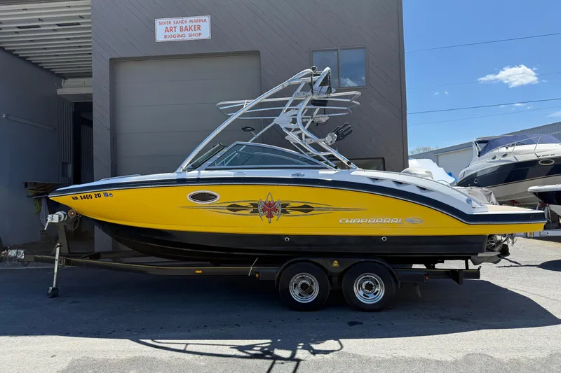 The Image of 2009 Chaparral Sunesta 244 Xtreme boat in yellow, parked on a trailer at a marina. - 0
