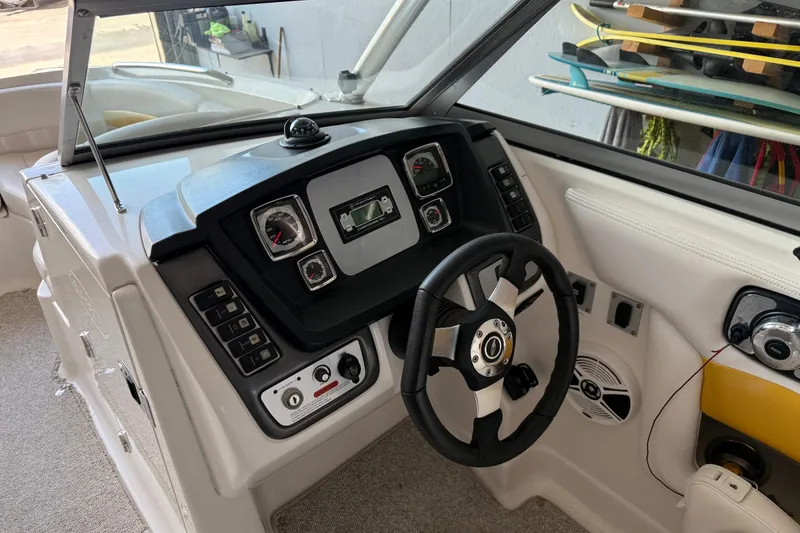 Slide: The Image of 2009 Chaparral Sunesta 244 Xtreme boat dashboard with steering wheel and control panel. - 13