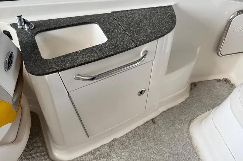 Slide: The Image of 2009 Chaparral Sunesta 244 Xtreme boat interior with sink and storage cabinet. - 16