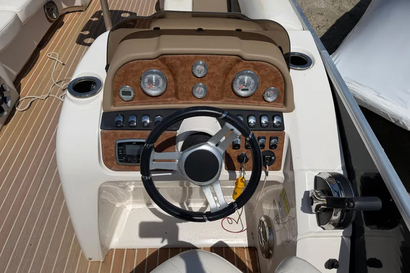 Slide: The Image of 2014 Cypress Cay Cozumel 240 boat dashboard with steering wheel and control panel. - 10