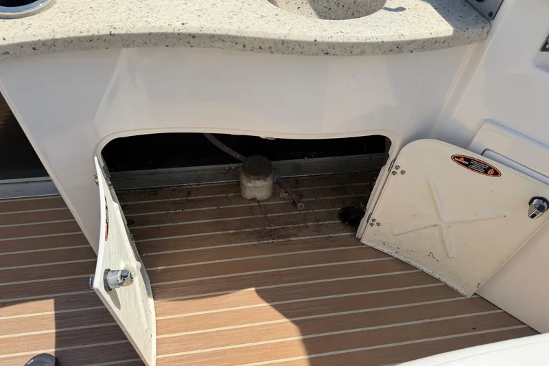 Slide: The Image of Open storage compartment on 2014 Cypress Cay Cozumel 240 boat with wooden flooring. - 17