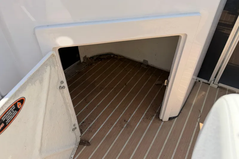 Slide: The Image of Open storage compartment on 2014 Cypress Cay Cozumel 240 boat with wooden flooring. - 18