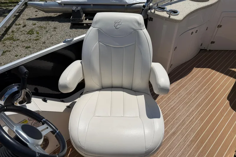 Slide: The Image of Captain's chair on 2014 Cypress Cay Cozumel 240 boat, featuring white upholstery and armrests. - 9