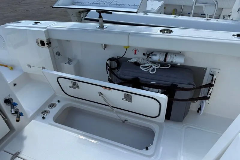 Slide: The Image of 2026 Pursuit S 358 Sport boat storage compartment with safety equipment and accessories. - 11
