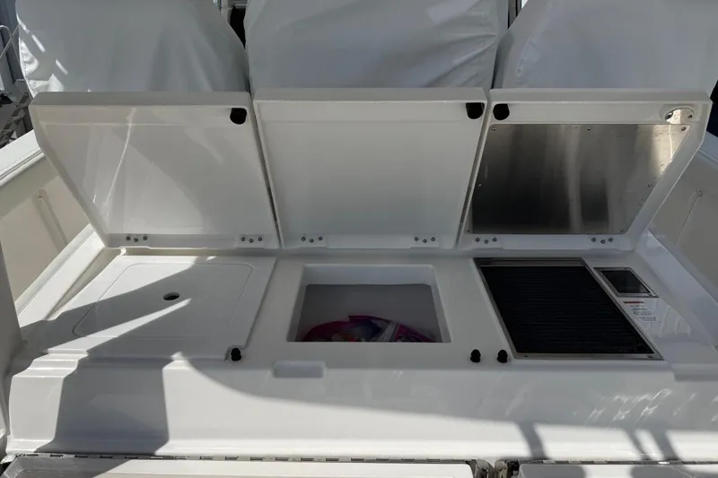 Slide: The Image of 2026 Pursuit S 358 Sport boat with open storage compartments and grill area. - 18